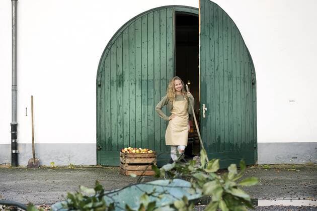 Smiling woman on a farm standing at crate with apples model released Symbolfoto property released  PESF00969