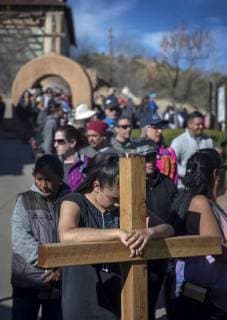 March 30, 2018 - U.S. - Jasmin Perez, 17, from Espanola, waits in line with her cross to enter the Santuario de Chimayo. Thousands of people were making their Good Friday pilgrimage to the Northern New Mexico Church, Friday March 30, 2018. Perez had walked from Santa Cruz. U.S. - ZUMAab1_ 20180330_zaf_ab1_010 Copyright: xEddiexMoorex