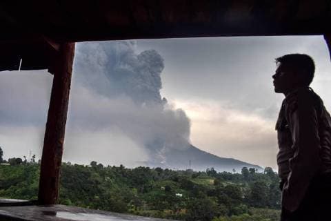(180407) -- NORTH SUMATERA, April 7, 2018 -- A man watches Mount Sinabung volcano spewing thick volcanic ash, seen from the town of Karo, North Sumatera, Indonesia, on April 6, 2018. ) (zxj) INDONESIA-NORTH SUMATERA-MOUNT SINABUNG-ERUPTION SARIANTO 
