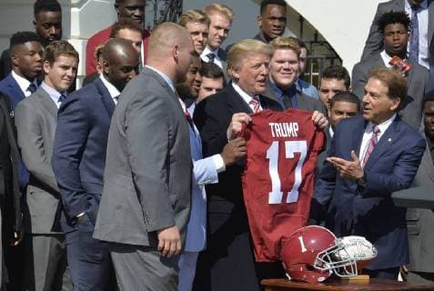 Entertainment Bilder der Woche Bilder des Tages President Donald Trump (C) holds up a jersey presented by University of Alabama Head Coach Nick Saban (R) and players from the NCAA National Champion Crimson Tide football team during a visit to the White House, April 10, 2018, in Washington, DC.  WAP20180410599 MIKExTHEILER