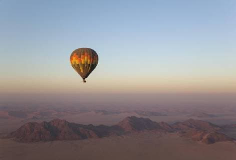 Heißluftballon über einer trockenen Ebene und einsamen Bergrücken, bei Tagesanbruch, Namib-Wüste, Luftaufnahme, NamibRand Nature Reserve, Namibia, Afrika Copyright: imageBROKER/ThomasxDressler ibltdr04661226.jpg