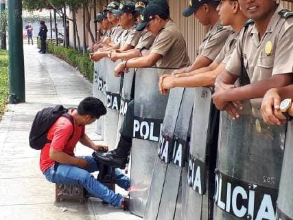 Themen der Woche KW15 Bilder des Tages A shoeshine boy cleans a policeman s shoes, in the surroundings of the 8th Summit of the Americas seat, in Lima, Peru, 13 April 2018. Security during the 8th Summit of the Americas !ACHTUNG: NUR REDAKTIONELLE NUTZUNG!  Copyright: xEliasxLevyx LIM301 20180413-636592453077629455