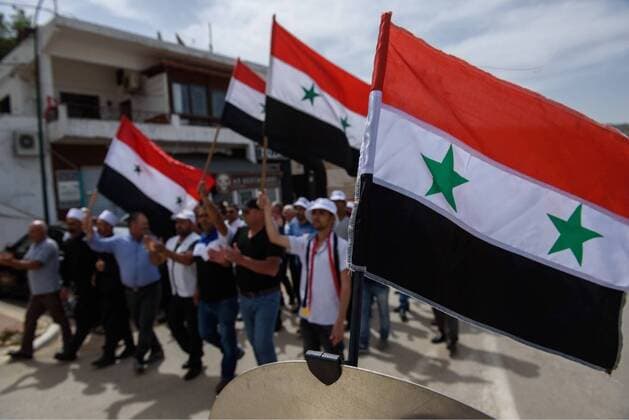 (180417) -- GOLAN HEIGHTS, April 17, 2018 -- Druze residents of the Ein Qiniye village in the Israeli-occupied Golan Heights hold the national flags of Syria as they march during a rally marking Syria s Independence Day on April 17, 2018. ) (zf) MIDEAST-GOLAN HEIGHTS-DRUZE-SYRIAN-INDEPENDENCE DAY AyalxMargolin-JINI 