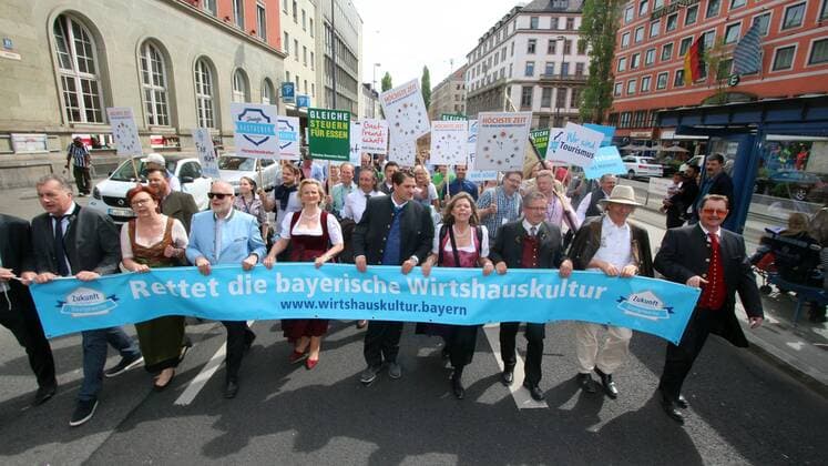 Bilder des Tages Großdemonatration und Arbeitsniederlegung von Mitarbeitern im Hotel und Gaststättengewerbe durch die DEHOGA Deutscher Hotel- und Gaststättenverband in München, Bayern, Deutschland: Landesgeschäftsführer Thomas Geppert mit Ingrid Hartges und Angela Inselkammer an der Spitze des Demozuges mit Spruchband rettet die bayerische Wirtshauskultur