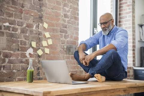 Businessman sitting on table in a loft using laptop model released Symbolfoto property released  FMKF04948