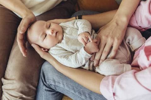 Midwife and mother giving newborn baby a belly massage to help with digestion model released Symbolfoto property released  MFF04397