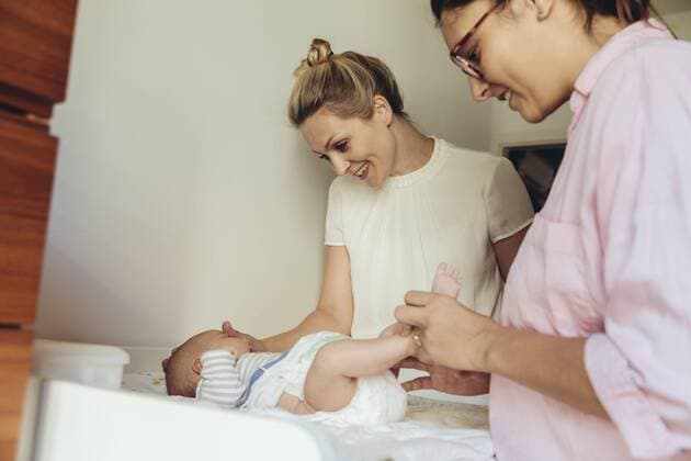 Midwife showing mother how to change diapers of newborn baby model released Symbolfoto property released  MFF04404