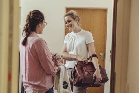 Woman greeting midwife at her home™s apartment door model released Symbolfoto property released  MFF04412