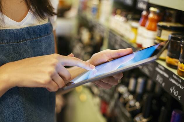 Close-up of woman using tablet at shelf in a store model released Symbolfoto property released  EBSF02222