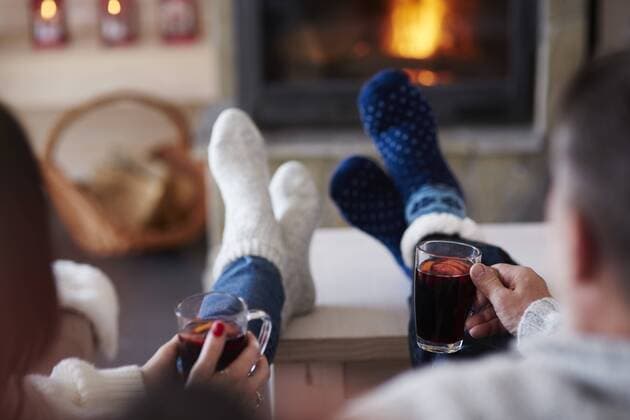Mature couple with hot drinks in living room at the fireplace model released Symbolfoto property released  ABIF00195