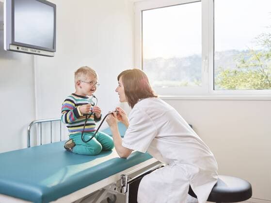 Female doctor and boy with stethoscope in medical practice model released Symbolfoto property released  CVF00189