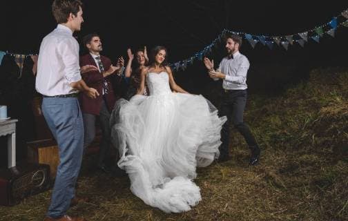 Happy bride dancing and having fun while her friends clapping on a night field party model released Symbolfoto property released  DAPF00946