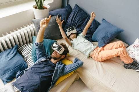 Father and son wearing VR glasses lying down at home model released Symbolfoto property released  KNSF03609