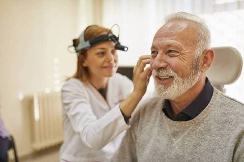 ENT physician examining ear of a senior man model released Symbolfoto property released  ZEDF01232