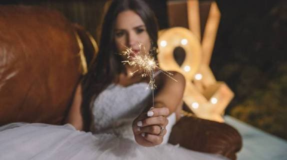 Close-up of sparkler in the hand of a bride lying on sofa on a night party outdoors model released Symbolfoto property released  DAPF00959
