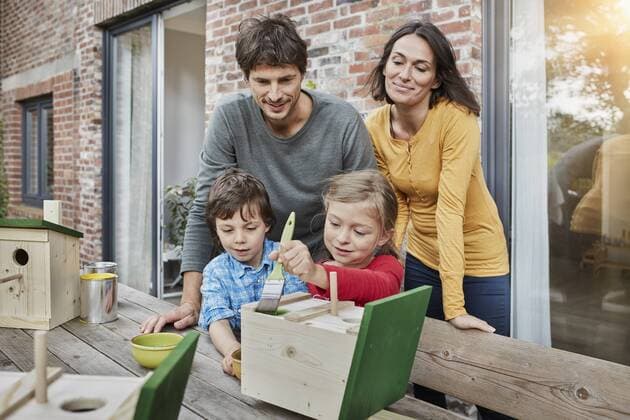 Family working on birdhouse in front of their home model released Symbolfoto property released  RORF01211