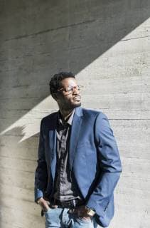 Businessman standing in sunshine at concrete wall looking away model released Symbolfoto property released  UUF13094