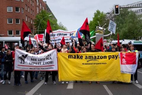 Protest Amazon Mehrere hundert Menschen protestieren anlässlich der Auszeichnung des Amazon-Gründers Jeff Bezos für sein visionäres Unternehmertum mit dem Axel Springer Award 2018. Unter dem Motto Kein Preis für Ausbeutung! ziehen Angestellte von Amazin aus Deutschland, Spanien und Polen zum Axel-Apringer-Hochhaus, um gegen die Arbeitsbedingungen des Online-Versandhändlers Amazon und für faire Löhne und Tarifvertraege zu protestieren. Demonstranten mit Banner: make amazon pay. Berlin Berlin Deutschland