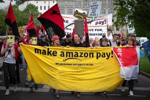 Protest Amazon Mehrere hundert Menschen protestieren anlässlich der Auszeichnung des Amazon-Gründers Jeff Bezos für sein visionäres Unternehmertum mit dem Axel Springer Award 2018. Unter dem Motto Kein Preis für Ausbeutung! ziehen Angestellte von Amazin aus Deutschland, Spanien und Polen zum Axel-Apringer-Hochhaus, um gegen die Arbeitsbedingungen des Online-Versandhändlers Amazon und für faire Löhne und Tarifvertraege zu protestieren. Demonstranten mit Banner: make amazon pay. Berlin Berlin Deutschland