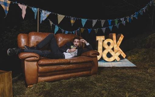 Portrait of man in suit posing on sofa on a night field party model released Symbolfoto property released  DAPF00951