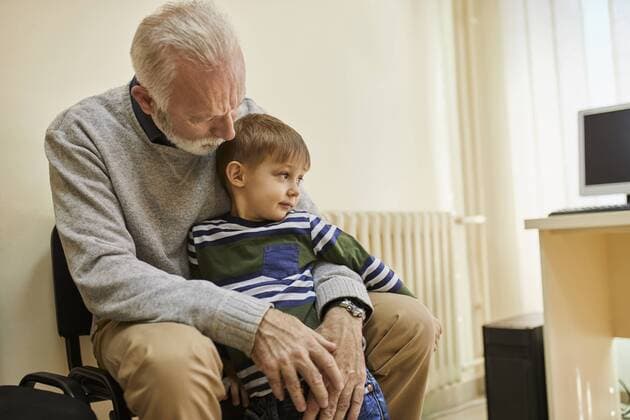 Boy sitting on grandfather s lap in waiting room model released Symbolfoto property released  ZEDF01240