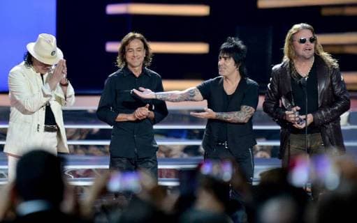 Carlos Santana (L) presents an award to Mana onstage during the 2018 Billboard Latin Music Awards at the Mandalay Bay Events Center in Las Vegas, Nevada on April 26, 2018.  LAV20180426335