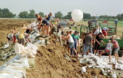 Freiwillige Helfer befüllen und stapeln am Montag (19.08.2002) bei Torgau an der Elbe Sandsäcke. Bundeswehr, Einsatzkräfte von DRK und THW, sowie viele Freiwillige versuchen bei der Hochwasserkatastrophe alles erdenkliche, um weitere Überflutungen zu verhindern.