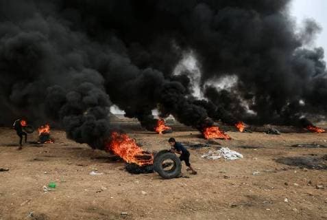 Themen der Woche KW 18 Bilder des Tages (180504) -- GAZA, May 4, 2018 -- A Palestinian boy rolls tires during clashes with Israeli troops on the Gaza-Israel border, east of Gaza City, on May 4, 2018. Clashes broke out Friday between dozens of Palestinian protestors and Israeli soldiers in eastern Gaza Strip close to the border with Israel during the sixth Friday of rallies and protests called the Great March of Return. ) (wtc) MIDEAST-GAZA-CLASHES Stringer 