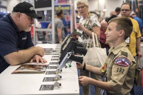 Themen der Woche KW 18 Bilder des Tages A convention attendee inspect a gun on the floor of the exhibition hall at the 147th National Rifle Association (NRA) Annual Meetings and Exhibits at the Kay Bailey Hutchison Convention Center in Dallas on May 5, 2018.  DAL20180505325 SERGIOxFLORES