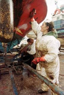 Freiwillige Helfer der spanischen Organisation Nunca Mais reinigen am Freitag (13.12.2002) in Cangas (Galicien) Werkzeuge vom Öl des gesunkenen Tankers Prestige. Zur Reinigung der Strände und Küstenabschnitte stehen ihnen nur einfachste Hilfsmittel zur Verfügung. Es fehlt überall an Geräten um die Strände vom Oel zu säubern. Aus dem Tanker, der mittlerweile gesunken ist, tritt noch immer Öl aus.