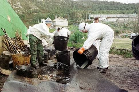 Freiwillige Helfer der spanischen Umweltorganisation Tragsa reinigen am Freitag (13.12.2002) einen Küstenabschnitt bei Mougas (Galicien), der vom Oel des gesunkenen Tankers Prestige verseucht ist. Zur Reinigung stehen ihnen nur einfachste Hilfsmittel zur Verfügung. Es fehlt überall an Geräten um die Strände vom Oel zu säubern. Aus dem Tanker läuft noch immer Öl aus.