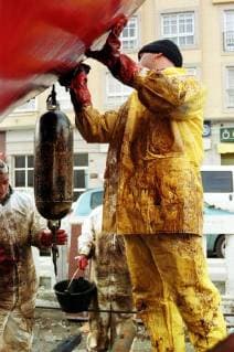 Freiwillige Helfer der spanischen Organisation Nunca Mais reinigen am Freitag (13.12.2002) in Cangas (Galicien) Boote vom Öl des gesunkenen Tankers Prestige. Zur Reinigung der Strände und Küstenabschnitte stehen ihnen nur einfachste Hilfsmittel zur Verfügung. Es fehlt überall an Geräten um die Strände vom Oel zu säubern. Aus dem Tanker, der mittlerweile gesunken ist, tritt noch immer Öl aus.