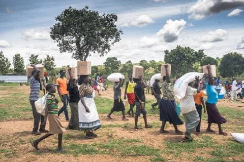 May 7, 2018 - Bidi Bidi, Uganda - South Sudanese refugees seen taking their food supplies provided by the World Food Program and walk back to their settlement from the food distribution point..The Bidi Bidi refugee settlement in northern Uganda near the South Sudanese border is currently the largest refugee camp in the world, hosting over 250,000 South Sudanese refugees fleeing the conflict. The world food program is providing monthly basic food supply for the refugees in the settlement. Bidi Bidi Uganda - ZUMAs197 20180507_zab_s197_005 Copyright: xGeovienxSox