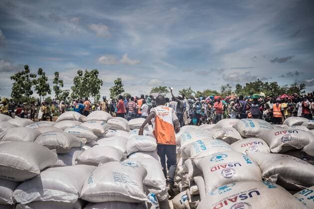 May 7, 2018 - Bidi Bidi, Uganda - A member of the world vision team which responsible to the food distribution rushing to the crowd of refugees through piles of food supplies as a fight is about to break out due to the refugees worry there aren t enough food to supply to everyone..The Bidi Bidi refugee settlement in northern Uganda near the South Sudanese border is currently the largest refugee camp in the world, hosting over 250,000 South Sudanese refugees fleeing the conflict. The world food program is providing monthly basic food supply for the refugees in the settlement. Bidi Bidi Uganda - ZUMAs197 20180507_zab_s197_003 Copyright: xGeovienxSox