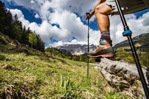 IMAGO Creative: Sommer, In den Bergen Bein eines Wanderers, mit Bergschuh und Stöcken auf Stein im Gebirge - Leg of a Mountain Hiker, with Shoe and Walking Poles, on Rock in the Mountains *** Leg of a Mountain Hiker with Shoe and Walking Poles on Rock in the Mountains  1098800036