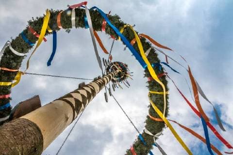 Maibaumtradition in Deutschland - Archivbilder Geschmückter Maibaum in Dorf in Bayern vor bewölktem Himmel Maibaum, Symbolfoto *** Adorned maypole in village in Bavaria in front of cloudy sky. Maypole symbol photo