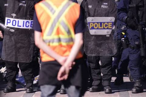 June 9, 2018 - Quebec City, Ontario, Canada - A protester wearing safety vest standing in front of the riot police during a rally to protest the G7 summit in Quebec City, Canada on 9 June 2018. During the last day of the G7 summit that is happening in La Malbaie, Quebec, protesters came on to the streets to protest the summit in Quebec City. Quebec City Canada  - ZUMAn230 20180609_zaa_n230_1052 Copyright: xArindamxShivaanix