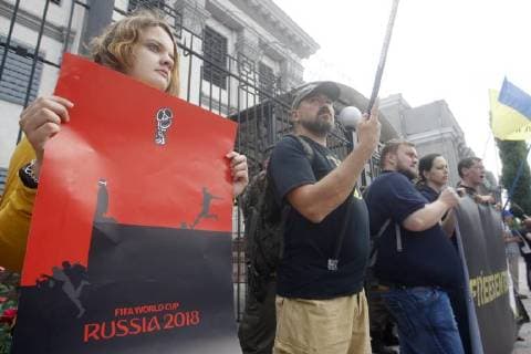 June 13, 2018 - Kiev, Ukraine - Ukrainian activists holds placards against the holding of the FIFA World Cup 2018 in Russia during a rally to support Ukrainian director Oleg Sentsov and other Ukrainian political prisoners in Russia, in front of the Embassy of Russia in Kiev, Ukraine, on 13 June 2018. Oleg Sentsov was sentenced by a Russian court on 25 August 2015 to 20 years in a high-security penal colony for terrorist attacks in Crimea annexed by Russia in April 2014. Kiev Ukraine - ZUMAg194 20180613_zap_g194_005 Copyright: xSergxGlovnyx