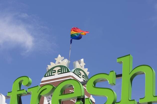June 18, 2018 - Seattle, Washington: Starbucks marks LGBTQ Pride month with the raising of the pride flag at their landmark headquarters building in Sodo. In the foreground is the Amazon s AmazonFresh sign from their grocery pick up location housed in the same building. - ZUMAg235 20180618_zap_g235_005 Copyright: xPaulxChristianxGordonx