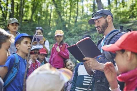 Man reading to kids on a field trip in forest model released Symbolfoto  ZEDF01393