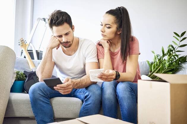 Serious couple sitting on couch in new home checking bills model released Symbolfoto property released  BSZF00399