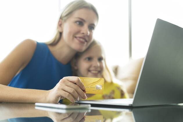Mother and daughter using laptop and credit card together model released Symbolfoto property released  SBOF01494