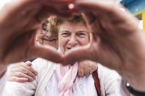 Portrait of happy senior woman shaping heart with her hands model released Symbolfoto  UUF13744