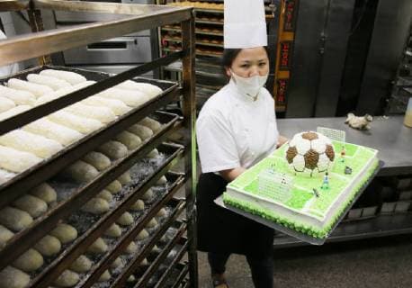 China: Football shaped cake Bakers make a World Cup themed cake at a bakery in Nantong, east China s Jiangsu Province. People can see football and football field at the cake. CHINA OUT Nantong Nantong China  XuxCongjun