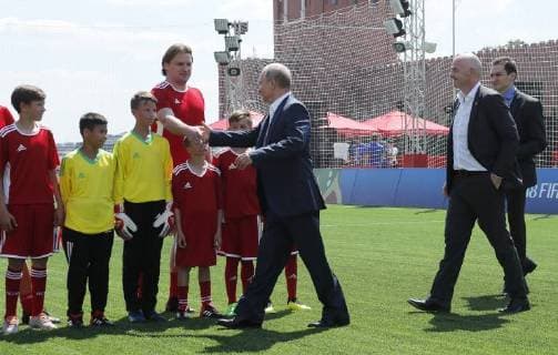 MOSCOW, RUSSIA - JUNE 28, 2018: Russia s President Vladimir Putin (C front) and Russian Football player Dmitry Bulyakin shake hands as FIFA President Gianni Infantino (R front) looks on as they visit the 2018 FIFA World Cup Football Park in Red Square. Mikhail Metzel TASS  TS086D70