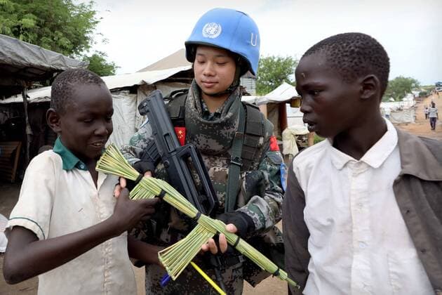 (180629) -- JUBA, June 29, 2018 -- Local children present a tool rifle to Chinese peacekeeper Yu Peijie (C) as a gift at No.1 refugee camp of the United Nations, South Sudan, on April 30, 2018. Yu Peijie, 26-year-old, is the leader of the female peacekeeper unit of Chinese peacekeeping infantry batallion to South Sudan. She has a nickname called Strong Elder Brother . However, she also has a soft heart. This year marks the 70th anniversary of UN peacekeeping. China began its participations in the UN peacekeeping operations in 1990. Today, China has some 2,500 peacekeepers and plays an important role in promoting and maintaining world peace. ) (dzl) SOUTH SUDAN-UN-CHINA-FEMALE PEACEKEEPER WangxTeng 