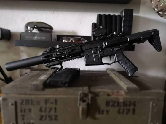 Airsoftwaffe M4 bzw. AR15 auf einer Munitionskiste mit Magazin, dahinter Schutzbrillen und Magazine auf einem Regal Themenbild, Symbolbild, Airsoft, Waffe, M4, AR15, 02.07.18 Solingen NRW Deutschland