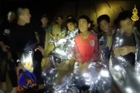 Members of the Royal Thai Navy are pictured with the 12 schoolboys, members of a local soccer team, and their coach, who were trapped in the Tham Luang Cave network in Northern Thailand. Two British volunteer divers found the missing boys Monday after a nine-day search. Screengrab via Thai Navy Seals  WAX2018070904 THAIxNAVYxSEALS
