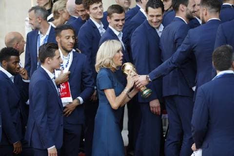 Brigitte Macron recoit des mains de Olivier Giroud le trophee FIFA World Cup en main, elle mesure le poids de cette recompense, sous le regard amuse des joueurs et membres du staff FOOTBALL : Equipe de France de Football recu au Palais de l Elysee - Paris - 16 07 2018 StephaneAllaman Panoramic 