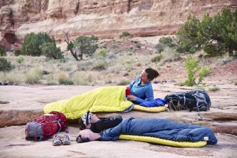 Side view of two women in sleeping bags while camping in Canyonlands National Park, Moab, Utah, USA, Moab UT USA HAMA001421 model released Symbolfoto Copyright: HagePhoto HAMA001421